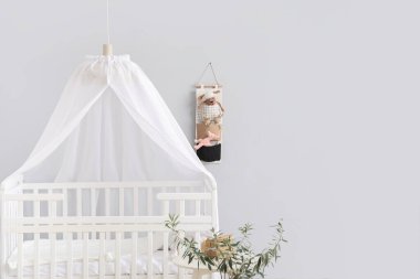 Modern çocuk odasının içinde rahat bir bebek beşiği.