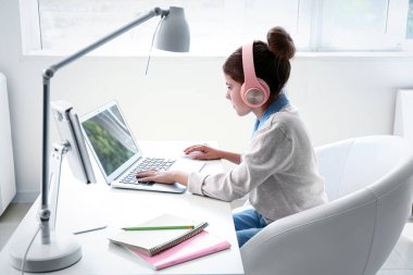 Küçük programcı ofiste dizüstü bilgisayarla çalışıyor