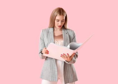 Pembe arka planda açık klasörü olan güzel bir genç kadın.
