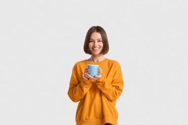 Hafif arka planda kahve fincanı olan güzel bir kadın.