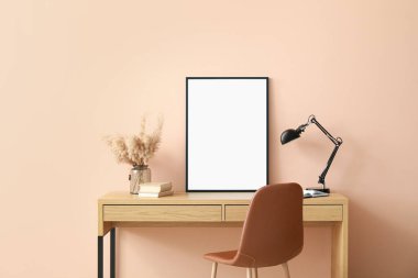 Renk duvarının yanında boş posteri olan şık bir iş yeri