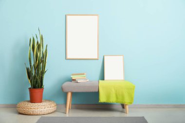 Renkli duvarın yanındaki boş posterli şık bank