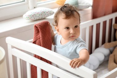 Beşiğinde ekose olan şirin bir bebek.