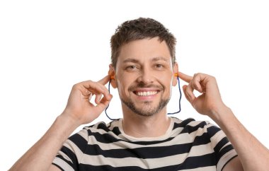 Beyaz arka planda kulak tıkacı olan gülümseyen yakışıklı bir adam.