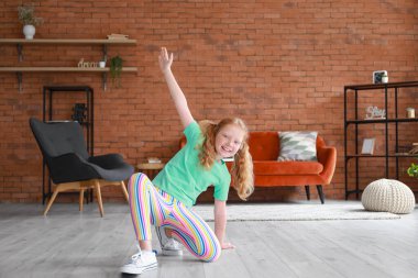 Evde dans eden yeşil tişörtlü küçük kızıl kız.