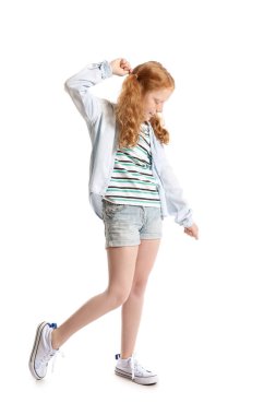 Beyaz arka planda dans eden at kuyruklu kızıl saçlı küçük kız.