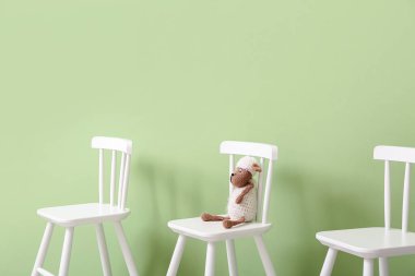 Beyaz modern sandalyeler ve arka planda koyun oyuncakları