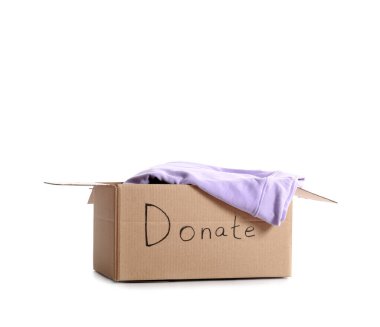 Beyaz arka planda bağış giysileri olan karton kutu.