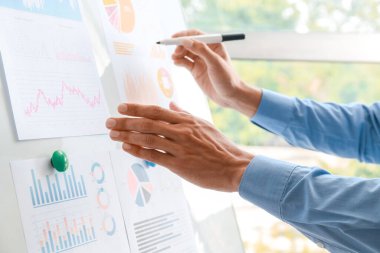 Ofisteki panoda belgelerle çalışan bir işadamı, yakın plan.