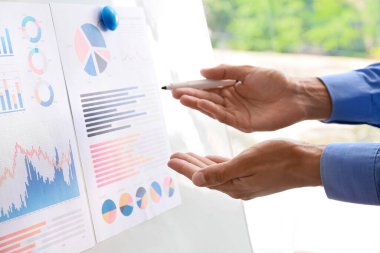 Ofisteki panoda belgelerle çalışan bir işadamı, yakın plan.