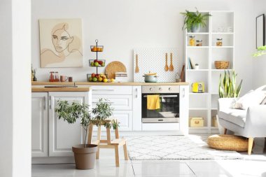 Beyaz tezgahları ve sağlıklı yiyecekleri olan, aydınlık, modern bir mutfak.