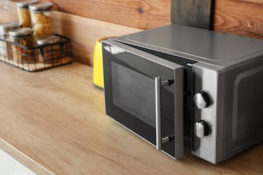 Mutfaktaki ahşap masa üstünde mikrodalga fırın.