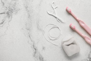 Kürdanlı diş ipi ve grunge arkaplanda fırçalar