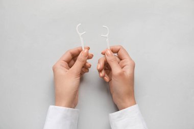 Işık arka planında diş ipi olan kadın.