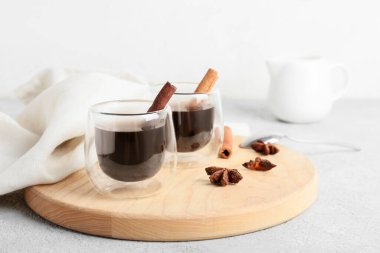 Hafif arka planda tarçınlı bir bardak lezzetli kahve.