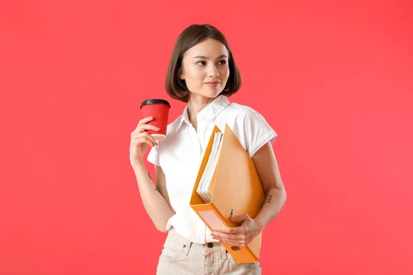 Schöne Junge Frau Mit Ordner Und Kaffee Auf Farbigem Hintergrund — Stockfoto