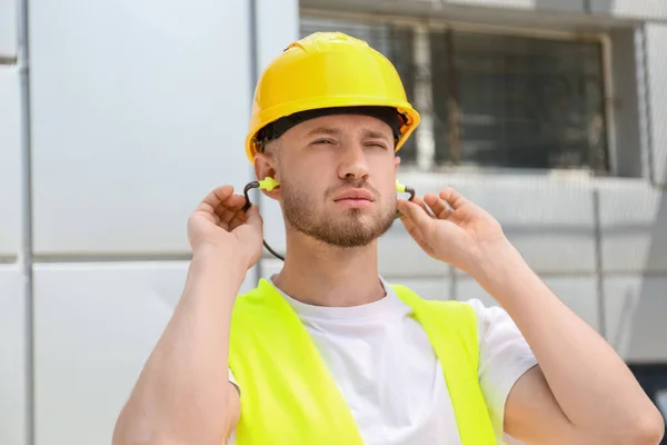 Male Worker Putting Ear Plugs Outdoors — Stock Photo, Image