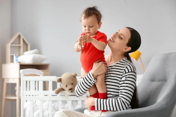 Genç Anne Bebeğini Oyuncak Ile Yatak Odasında Tutuyor — Stok fotoğraf