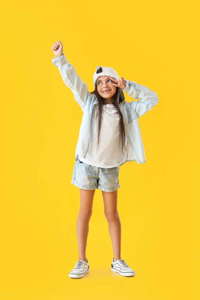 Sarı Arka Planda Dans Eden Şapkalı Sevimli Küçük Kız — Stok fotoğraf