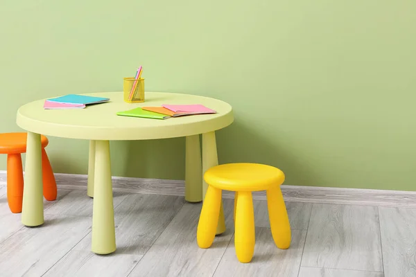 Çocuk Odasındaki Renkli Duvarın Yanında Sandalye Kırtasiye Malzemeleri Olan Masa — Stok fotoğraf