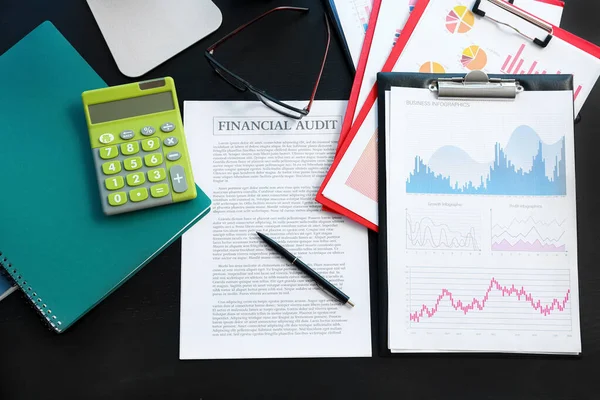 Ofisteki masada kalem, hesap makinesi ve gözlüklü iş belgeleri