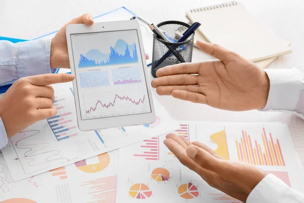 Tablet bilgisayarlı iş kadını ve masadaki meslektaşı, yakın plan.