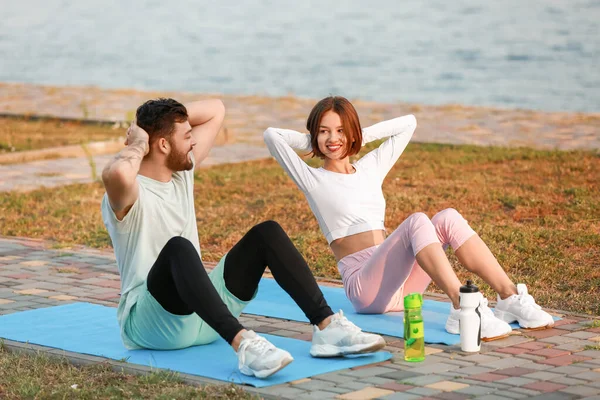Sporty Young Couple Exercising Mats River — 图库照片