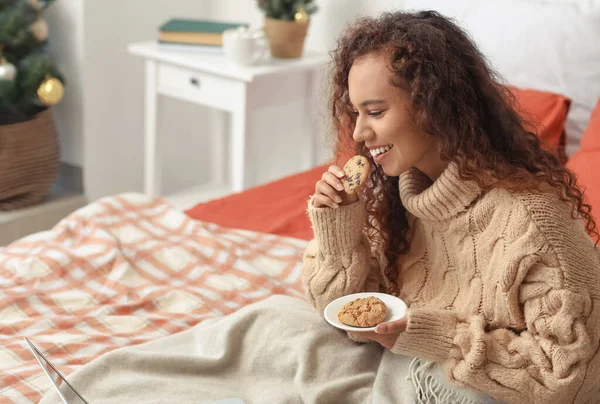 Jonge Afro Amerikaanse Vrouw Met Koekjes Kijken Film Slaapkamer Kerstavond — Stockfoto