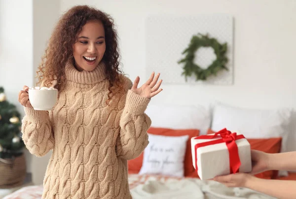Young African American Woman Cup Cocoa Receiving Christmas Gift Bedroom — Stockfoto