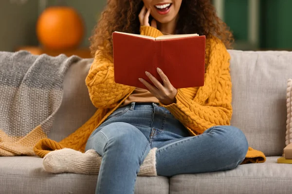Surprised Young African American Woman Reading Book Sofa Home — Stock Photo, Image