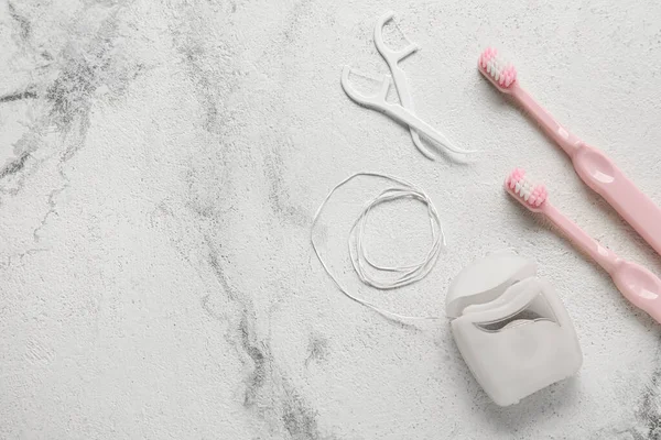 Kürdanlı diş ipi ve grunge arkaplanda fırçalar