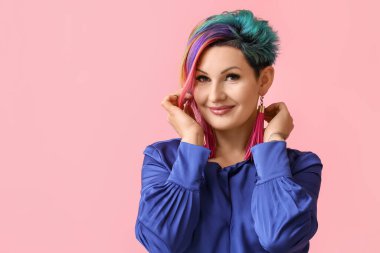 Renkli arka planda sıradışı saçları olan güzel bir kadın.