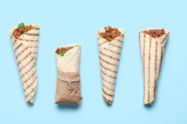 Mavi arka planda farklı lezzetli dürümler.