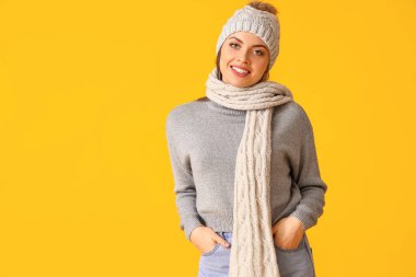 Kalın kış kıyafetleri içinde, renkli arka planda güzel bir kadın.
