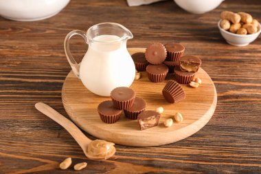 Ahşap zemin üzerinde fıstık ezmesi olan lezzetli çikolata şekerli bir tahta.