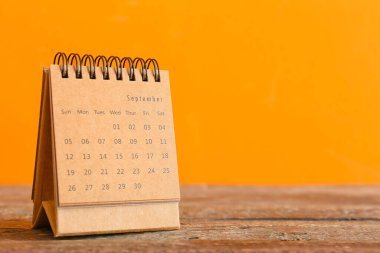 Ahşap masadaki takvim turuncu arka planda