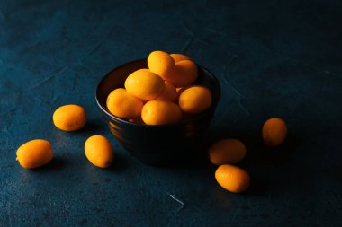 Koyu arkaplanda lezzetli kumkatlı meyve tabağı