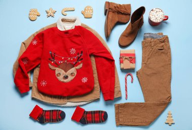Arka planda Noel hediyesi olan çocuk kıyafetleri.