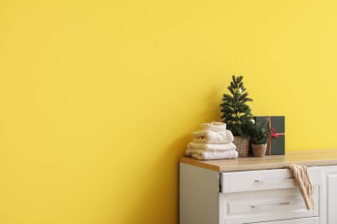 Noel ağaçlı sıcak kazaklar ve odadaki çekmecelerin üstünde hediye.