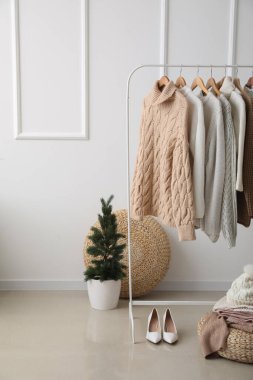 Soyunma odasında askı ve aksesuarlarda şık süveterler.