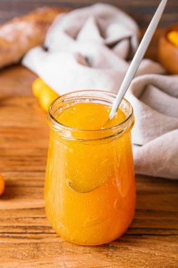 Ahşap arka planda lezzetli kumkuat reçeli kavanozu