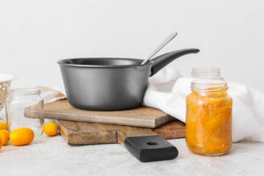 Taze kumkat reçelli kavanoz ve beyaz arka planda taze meyve.