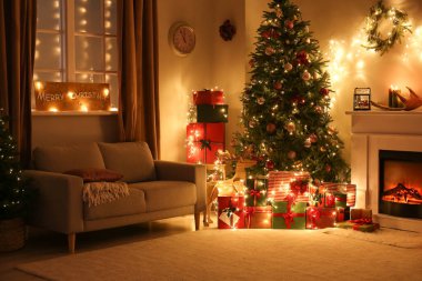 Geceleri güzel Noel ağacı ve şöminesi olan şık bir oturma odası.