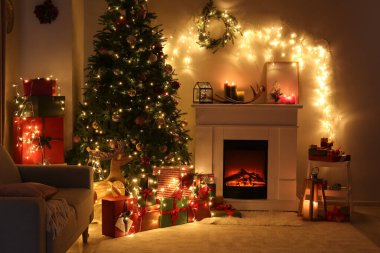 Geceleri güzel Noel ağacı ve şöminesi olan şık bir oturma odası.