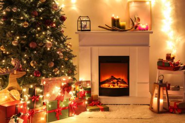 Güzel Noel ağacı olan bir şömine ve geceleri oturma odasında hediyeler.