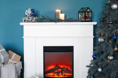 Güzel süslemeleri ve oturma odasında Noel ağacı olan bir şömine.