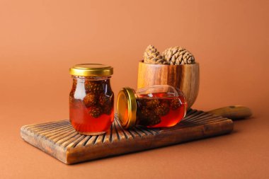 Renkli arka planda lezzetli kozalak reçeli kavanozları olan tahta