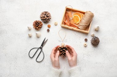 Kadın hafif arka planda el yapımı Noel oyuncakları yapıyor.