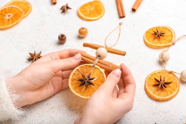 Kadın hafif arka planda el yapımı Noel oyuncakları yapıyor.