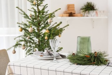 Noel için dekore edilmiş odada çam kozalakları ve köknar dallarıyla güzel bir masa.